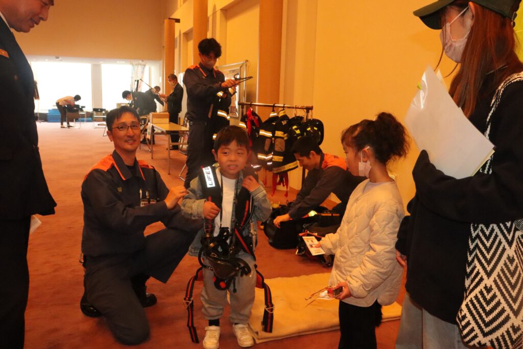 防火服の試着を体験する子どもたち