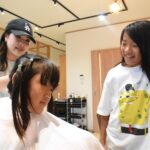 頭髪を寄付するため、2年半伸ばし続けた髪を切ってもらう保田優君（右）と弟の佑君=岡山県津山市で