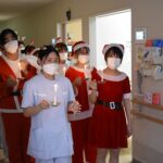 キャンドルを手に、クリスマスソングを歌いながら病棟を巡る学生たち=岡山県津山市川崎の津山中央看護専門学校で