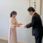萩原市長から任用通知書を受け取るグエットさん