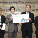 総額74万円分のクーポン券の目録を手にする（左から）光井聡市長、ナンバホームセンターの江見幸敏管理本部長、同社関係者