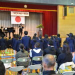 卒業生の入江さんの演奏で校歌を歌い上げる児童=岡山県久米南町で