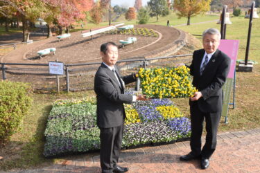 花苗を手にする藤井常務理事（右）と松原部長=岡山県津山市で