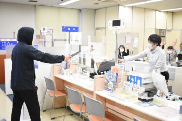 刃物で脅し、現金を奪おうとする犯人役=岡山県津山市で