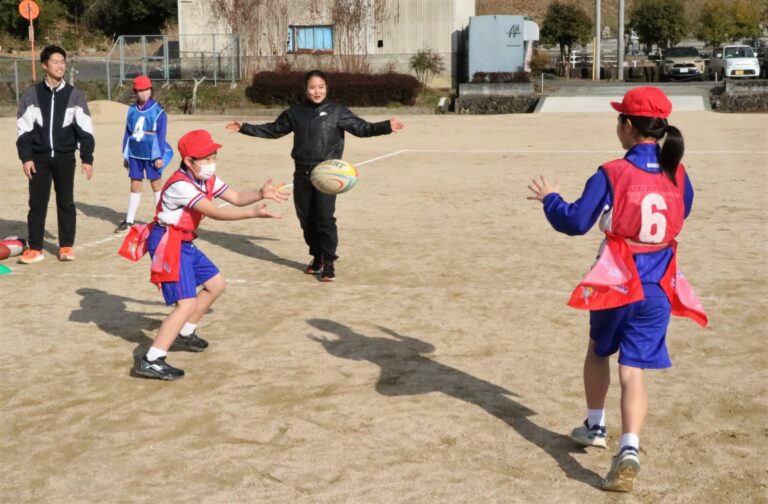 藪内さんのアドバイスを受けながらパスを練習する児童