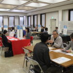真剣に担当者から説明を聞く求職者たち=岡山県津山市で