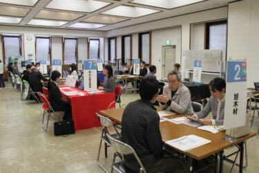 真剣に担当者から説明を聞く求職者たち=岡山県津山市で
