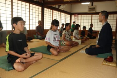 静かに呼吸をしながら座禅に取り組む子どもら=岡山県津山市で