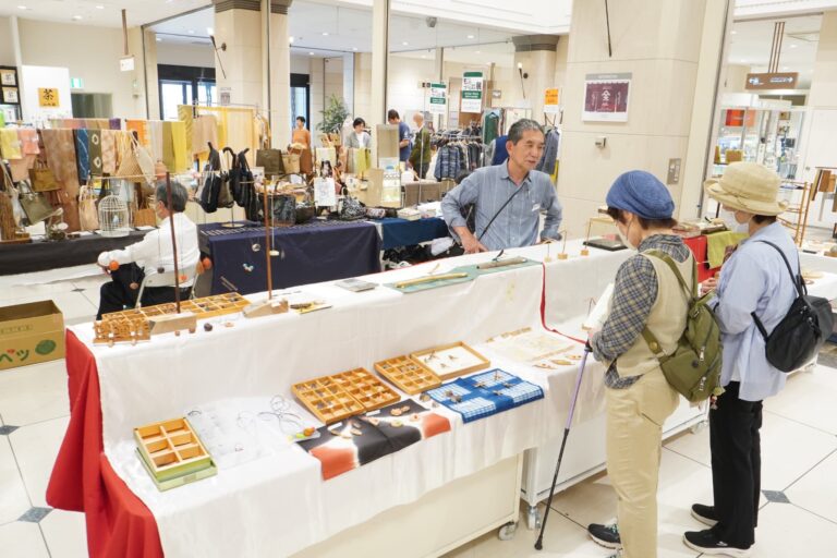 地域の伝統工芸や民芸品に見入る来場者