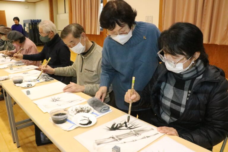 大谷さん（右から２人目）の助言を受けながら水墨画を描く参加者