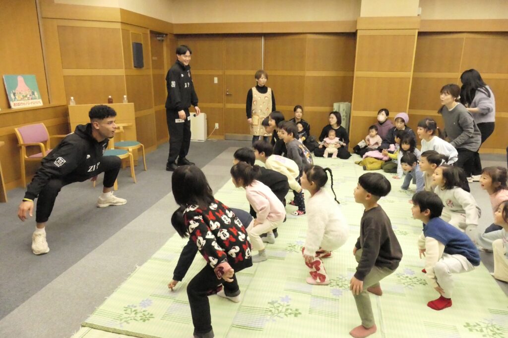 選手たちの動きに合わせて体操する子どもら