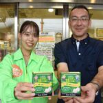 啓発キャンデー「ロマンスあめ」を手にする田邊社長と県の担当者=岡山県津山市、道の駅・久米の里で