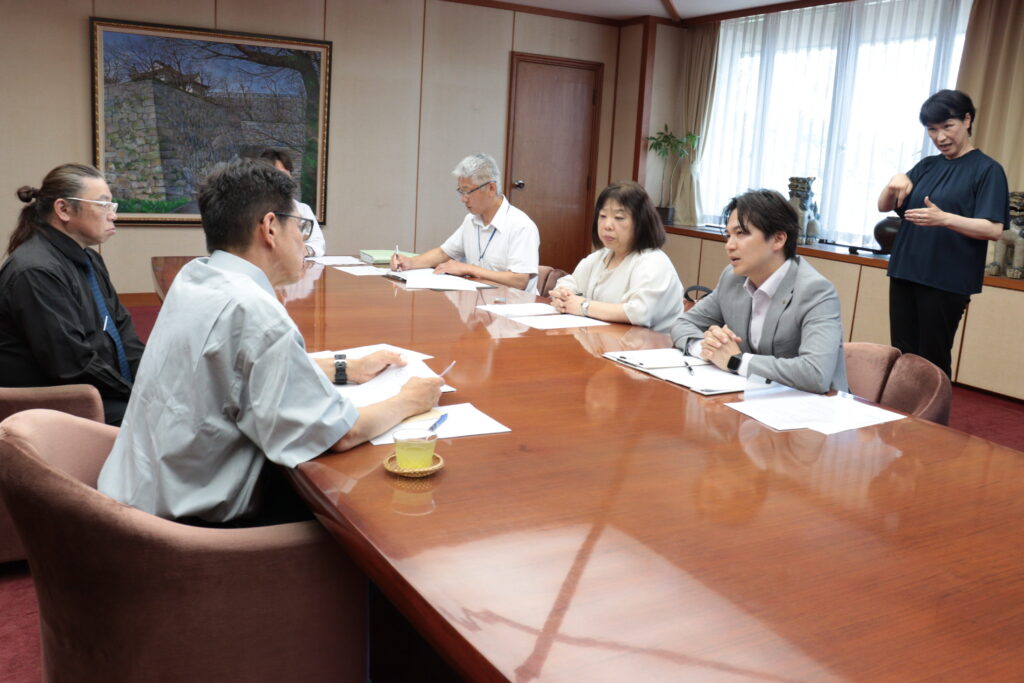 手話通訳者を介して話し合う光井市長と池口事務局長ら